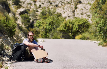 Fototapeta na wymiar Hitch-hiking traveler with a blank cardboard sign