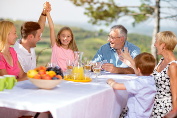 Family smiling and playing card in nature .