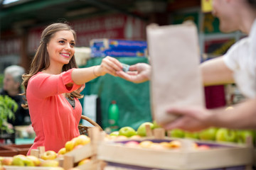 woman with money buying at market..