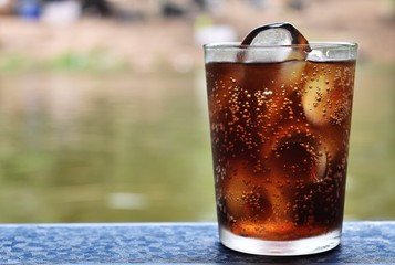 Detail cola and ice in glass in relax time on holiday