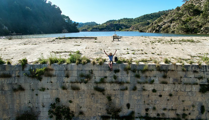 Man traveler sitting on a edge of the dam. Spain