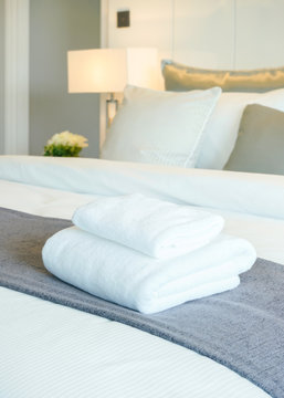 White towels on bed in modern bedroom interior