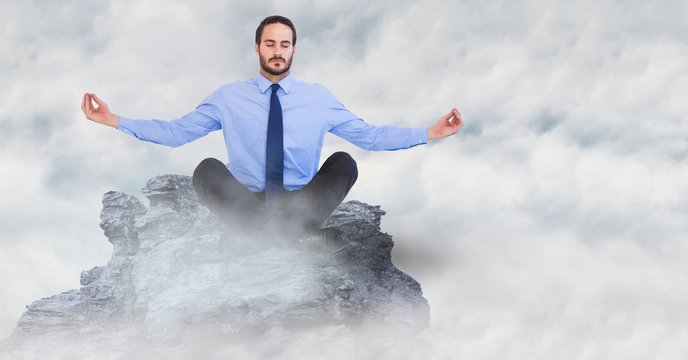 Business Man Meditating On Mountain Peak In The Clouds