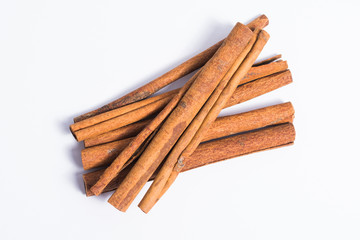 Pile of cinnamon sticks on white background
