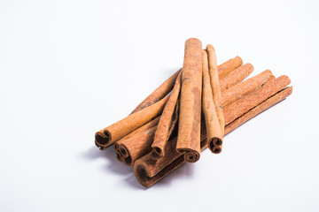 Pile of cinnamon sticks on white background