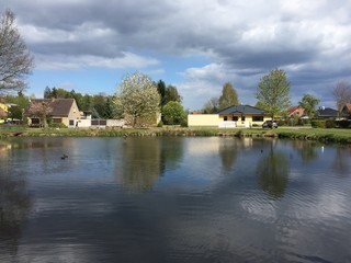 Fototapeta na wymiar Dorf am Teich, Bäume, Wald, See, Wolken, Frühling