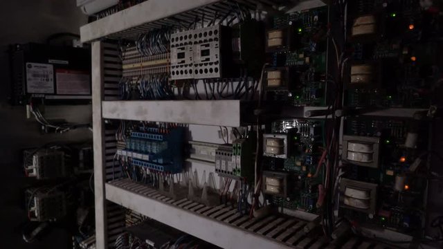 Tracking shot of electrical panel with fuses, relay, switches and contactors.