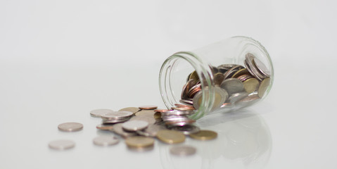 Glass jar saving money with coin on white background.
