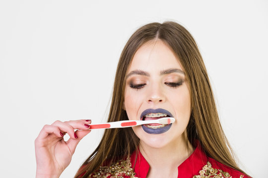girl with teeth braces and brush, has fashionable makeup