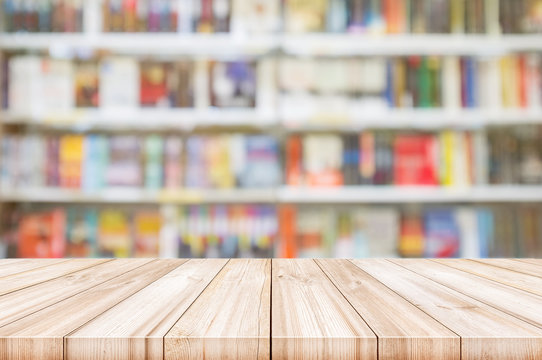Empty wooden table top with Blur bookshelves in bookstore background.