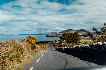Kurvige Straße mit Reifenabdrücken auf dem Asphalt an der Küste von Irland
