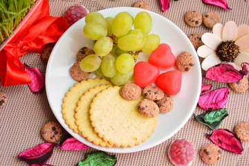 Breakfast of crackers, grapes and marmalade on a saucer