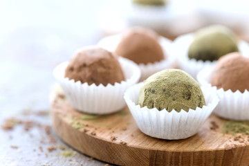 Close up homemade healthy vegan chocolate truffles rolled cocoa and matcha powder Copy space