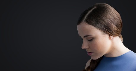 Woman looking down against dark grey background