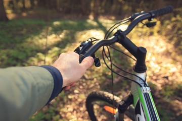 Hands of a man on the wheel of a bicycle. Steering wheel close-up