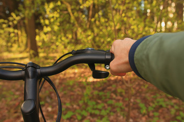 Fototapeta na wymiar Hands of a man on the wheel of a bicycle. Steering wheel bike close-up.