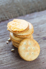 Crackers with cream on wooden background
