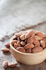 Almond seeds in a bowl on wooden table