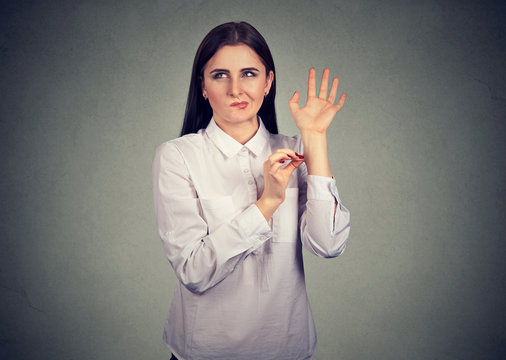 Confused woman pinching herself in disbelief of what just happened