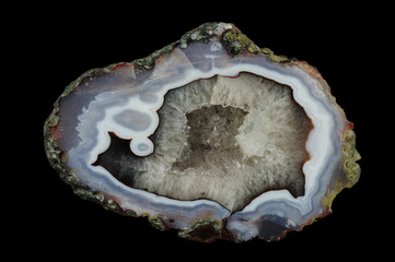 Obraz premium A cross section of the agate stone with quartz geode. Multicolored silica rings colored with metal oxides are visible. Origin: Asni, Atlas Mountains, Morocco.