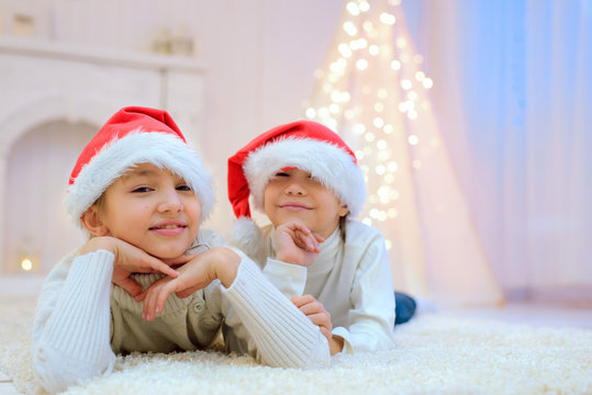 boy and girl in Christmas lie under the tree