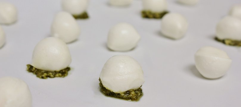Small mozzarella balls and green pesto