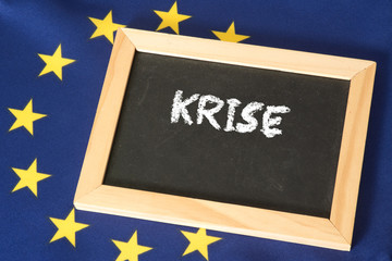 Flagge der EU und eine Kreidetafel mit dem Wort Krise