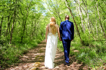 Wedding. Wedding couple at forest. Beautiful bride and groom walking along the forest path. A wedding couple who stay and enjoy in the natural beautiful landscape.