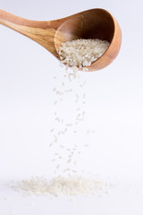 Spoon of rice falling on a white background. Rice falling down from a spoon