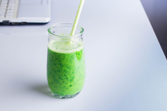 Healthy Drink Smoothie from Green Spinach and Apples in jar and computer on white table. Vegetarian and Diet Detox Drink Concept. Copy space, horizontal image
