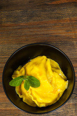 Sweet pumpkin ravioli with banana on a wooden background. with copy space. top view