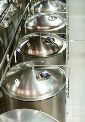 Several glossy steel cylindrical tanks.