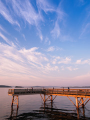 Fototapeta premium Wooden fishing pier extending from the shore into the ocean. Sidney BC, Vancouver Island