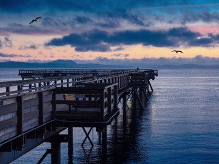 Fototapeta premium Wooden fishing pier extending from the shore into the ocean. Sidney BC, Vancouver Island