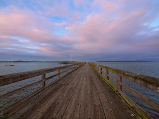 Obraz premium Wooden fishing pier extending from the shore into the ocean. Sidney BC, Vancouver Island