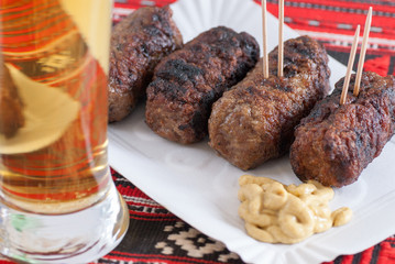 delicious roasted meat rolls romanian mititei mici with mustard and glass of beer