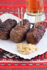 delicious roasted meat rolls romanian mititei mici with mustard and glass of beer