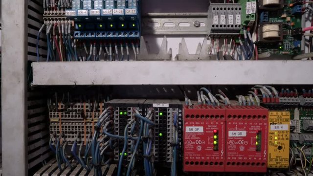 Tracking shot of electrical panel with fuses, relay, switches and contactors.