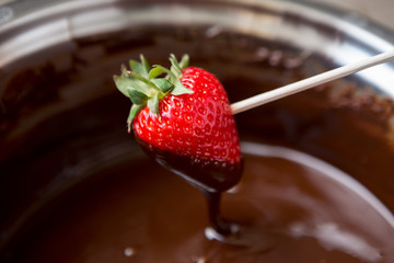 Dipping strawberries in dark chocolate.