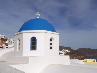 Fototapeta na wymiar The unique pure white and vivid blue Greek islands style church at Oia village on Santorini island, Greece 