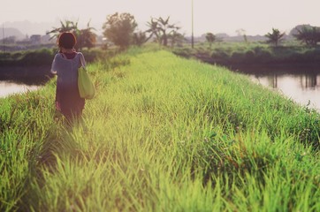 Girl in backlight on short grass