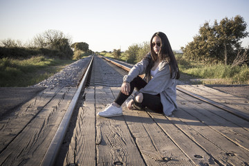 Joven sentada en las v&iacute;as del tren