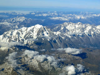 Super clear aerial view of the Alps in snow cover with blue sky