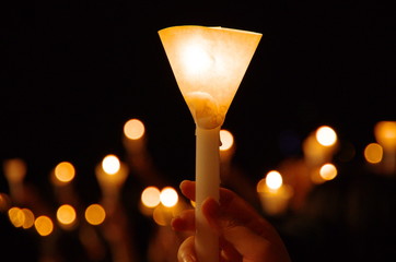 candlelight vigil with shallow depth of field creating round bokeh