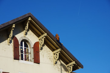 Fototapeta na wymiar a house with old roof and chimney under blue sky