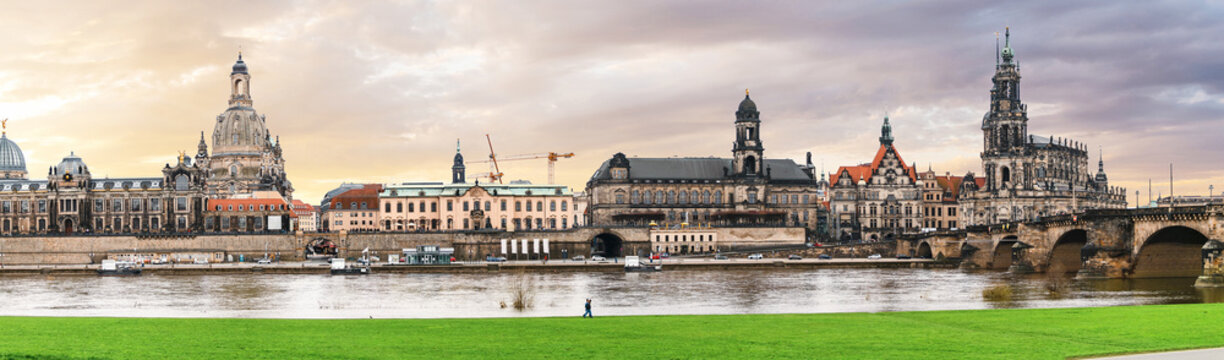 Panoramic view of Dresden city most famous landmarks in a beautiful sunny day with grass field on the bank of Elbe river with bridge