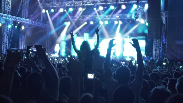 Inspired crowd dancing to music rhythm at music concert, extra slow motion