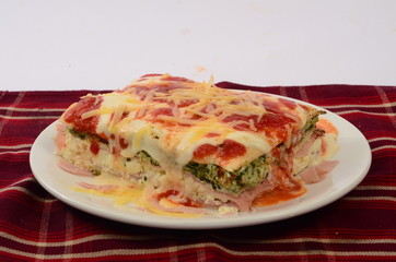 Lasaña con queso, salsa pomodoro y rellena de verdura espinaca y jamón