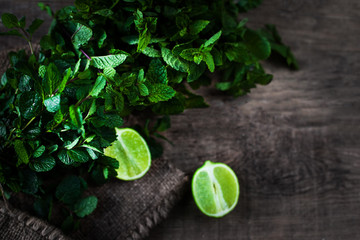 Ingredients for mojito. Fresh mint, limes, sugar over wooden  background