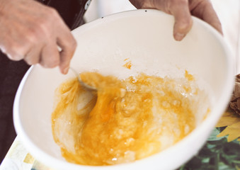 Grandmother preparing batter for pancakes